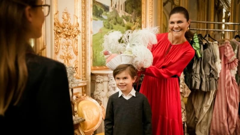 Kronprinzessin Victoria hat mit ihren Kindern im Backstage-Bereich der Oper in Stockholm für Spaß. Gerade hilft sie ihrem Sohn Prinz Oscar dabei, einen Cupcake-Hut mit Federn anzuprobieren. (Bild: Sören Vilks / TT News Agency / picturedesk.com)