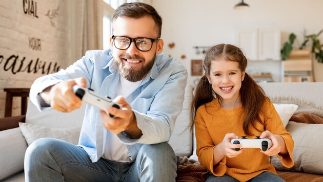 Kinder der Siebziger und Achtziger, die mit Videospielen aufgewachsen sind, sind mittlerweile oftmals selber Eltern - und frönen dem Hobby gemeinsam mit dem Nachwuchs. (Bild: stock.adobe.com)