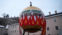 Die Klimaaktivisten der Bewegung Erde Brennt brachten am Kapitelplatz in der Salzburger Altstadt ein riesiges Transparent an. (Bild: Erde Brennt Salzburg)