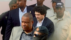 FTX-Gründer Sam Bankman-Fried (Bildmitte) unterwegs zum Gericht von Nassau (Bild: AFP)