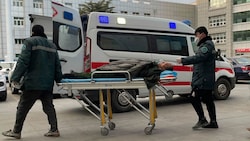 Medizinisches Personal schiebt einen Mann an einem Krankenwagen im Krankenhaus in der chinesischen Stadt Zhuozhou in der Provinz Hebei vorbei. (Bild: The Associated Press)
