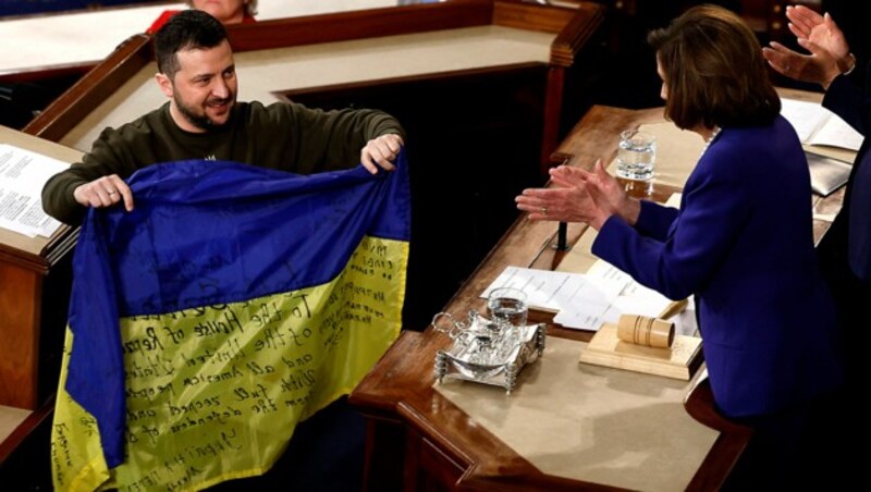 Selenskyj überreicht Pelosi eine ukrainische Flagge aus der umkämpften Stadt Bachmut. (Bild: APA/Getty Images via AFP/GETTY IMAGES/Anna Moneymaker)