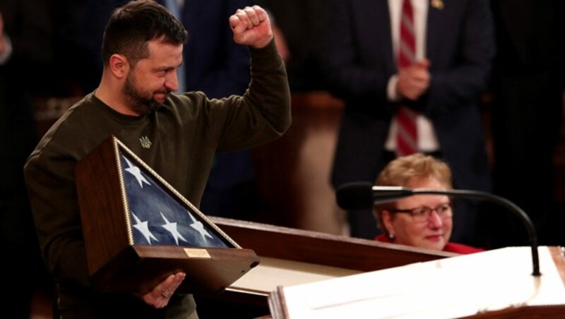 Selenskyj nach seiner Rede im US-Kongress mit geballter Faust und einer US-Flagge (Bild: APA/Getty Images via AFP/GETTY IMAGES/WIN MCNAMEE)