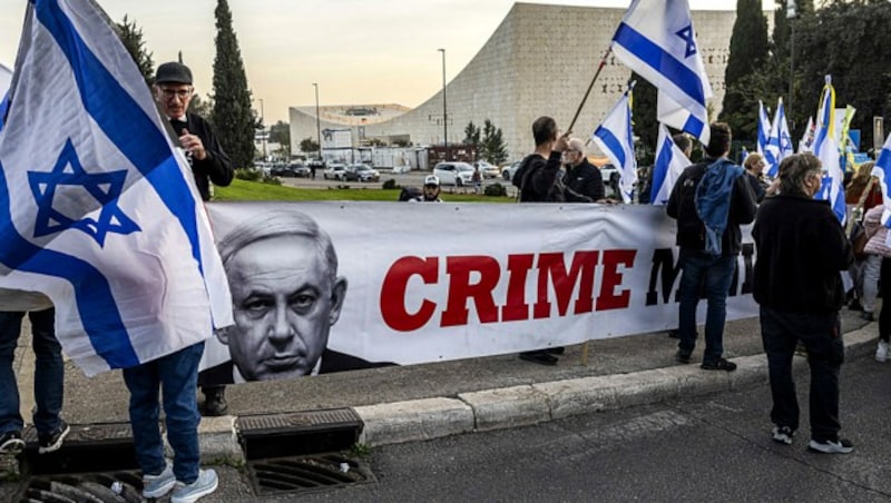 Linke Aktivisten auf einer Kundgebung gegen Netanyahu, den sie als „Kriminalminister“ sehen (Bild: APA/AFP/MENAHEM KAHANA)