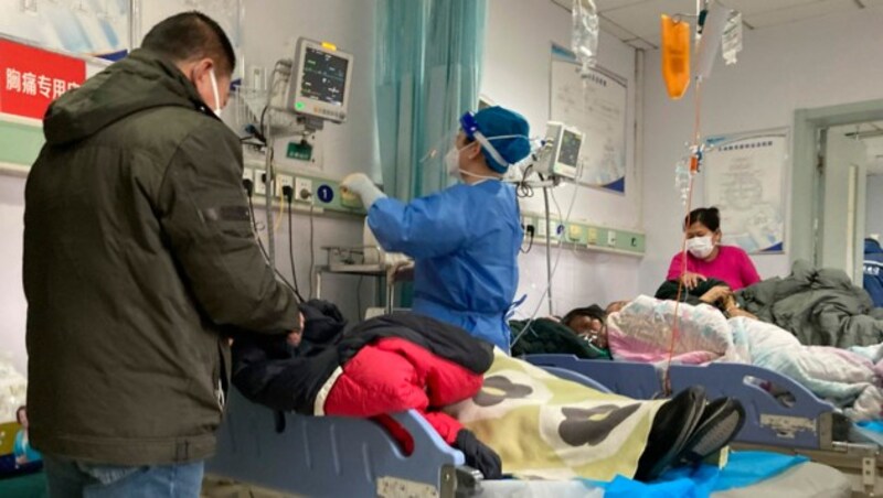 Die Krankenhäuser in vielen chinesischen Städten sind hoffnungslos überfüllt - Patienten müssen teilweise auf Parkplätzen vor Spitälern oder am Gang behandelt werden. (Bild: Associated Press)