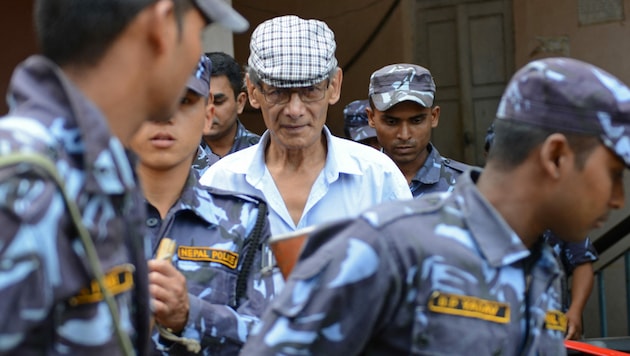 Ein Foto aus dem Jahr 2014 zeigt den französischen Serienmörder Charles Sobhraj, als er von der nepalesischen Polizei zu einer Anhörung vor einem Bezirksgericht in Bhaktapur eskortiert wird. (Bild: APA/AFP/Prakash MATHEMA)