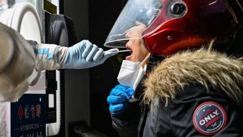 Ein Mitarbeiter des Gesundheitswesens entnimmt einer Frau in Shanghai eine Abstrichprobe, um sie auf das Coronavirus zu testen. (Bild: AFP)