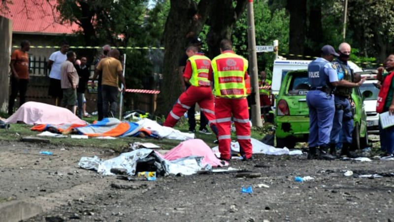 Leichen liegen bedeckt an der Stelle, an der der Gastankwagen unter der Brücke in Boksburg explodiert ist. (Bild: ASSOCIATED PRESS)