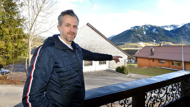 Markus Peintner zeigt auf das Gebäude, wo der Traktor in Vollbrand stand. (Bild: ZOOM.TIROL)