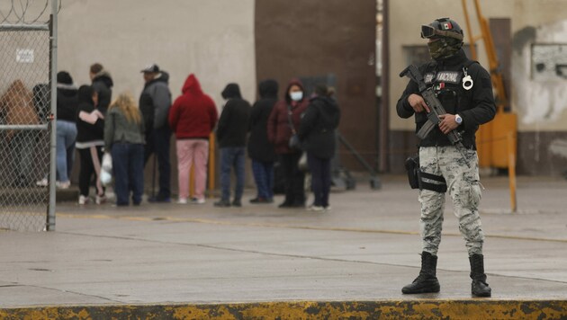 Ein Nationalgardist sichert einen Bereich ab, während Angehörige von Insassen vor dem Gefängnis auf Informationen warten. (Bild: AFP)