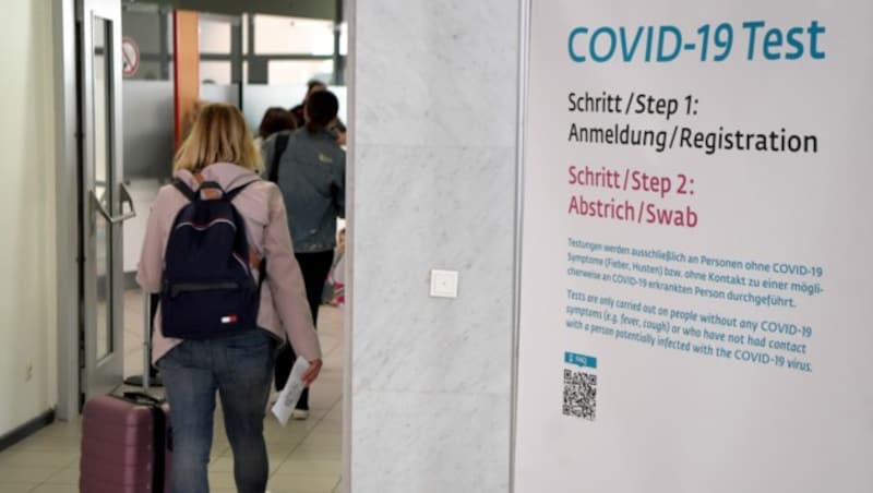 Ein Hinweis auf die Covid-19-Testeinrichtungen am Flughafen Wien (Bild: APA/ROLAND SCHLAGER)