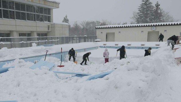 Für das Testprojekt wurde das Schwimmbecken einer verlassenen Volksschule mit Isoliermaterial (hellblau) versiegelt, um darin angehäuften Schnee kalt zu halten. (Bild: AFP/Kyodo)