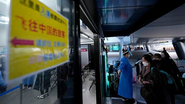 Gelandete Passagiere aus China werden in eine südkoreanische Teststraße gelotst. (Bild: AP)