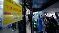 Gelandete Passagiere aus China werden in eine südkoreanische Teststraße gelotst. (Bild: AP)