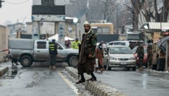 Nach dem Anschlag wurde die Straße abgesperrt, ein Mitglied der Taliban hält Wache. (Bild: APA/AFP/Wakil KOHSAR)