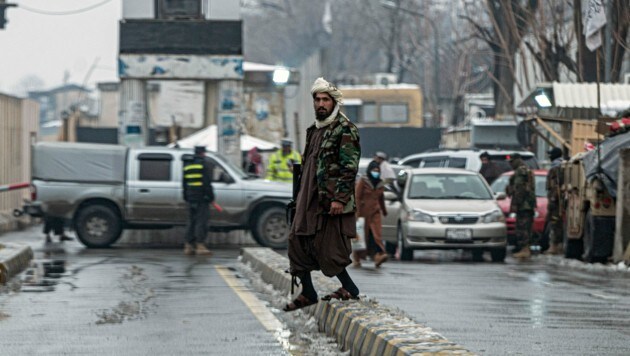 Nach dem Anschlag wurde die Straße abgesperrt, ein Mitglied der Taliban hält Wache. (Bild: APA/AFP/Wakil KOHSAR)