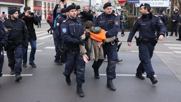 Mehrere Aktivisten der Letzten Generation machten ihren Klima-Unmut im Kreuzungsbereich nahe der Secession bzw. dem Naschmarkt mit einem Klebe-Protest kund. Die Polizei löste die Blockaden auf. (Bild: APA/FLORIAN WIESER, Krone KREATIV)