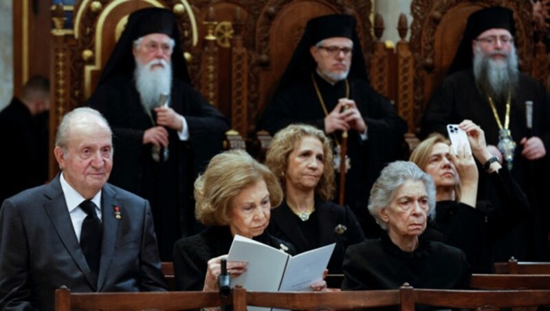 Der ehemalige spanische König Juan Carlos, Spaniens ehemalige Königin Sofia und die ehemalige Prinzessin Irene nehmen an der Trauerfeier für den ehemaligen griechischen König Konstantin II. in der Kathedrale von Athen teil. (Bild: APA/Photo by STOYAN NENOV / POOL / AFP)