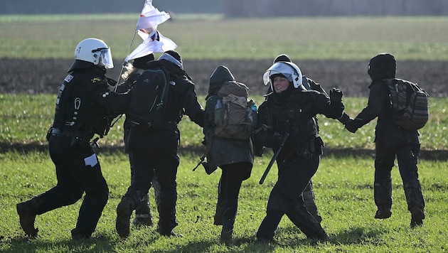 Klimaaktivisten werden in Keyenberg in der Nähe von Lützerath von Polizisten abgedrängt. (Bild: APA/AFP/INA FASSBENDER)