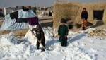 Afghanische Binnenvertriebene schaufeln an einem kalten Wintertag in der Provinz Balkh Schnee in der Nähe ihrer Zelte. (Bild: AFP)