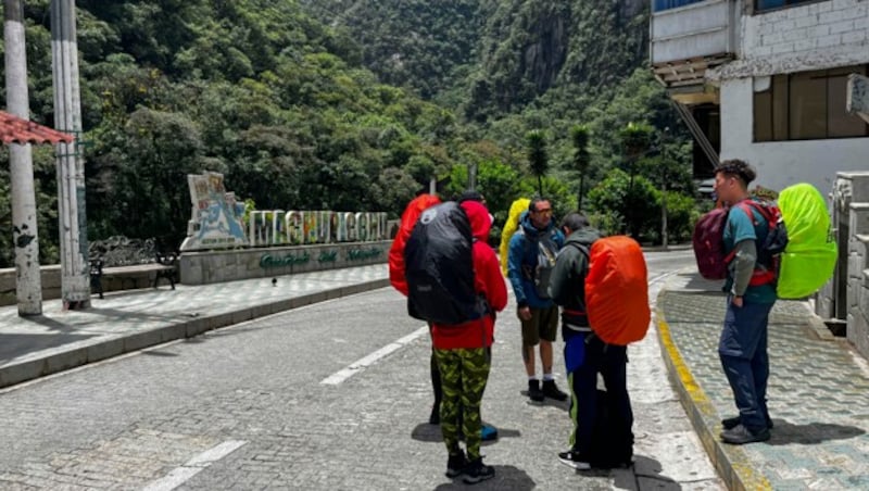 Touristen warten vor dem Bahnhof von Machu Picchu, nachdem der Zugverkehr aufgrund von angeblich durch Demonstranten verursachten Schäden eingestellt wurde. (Bild: AFP)