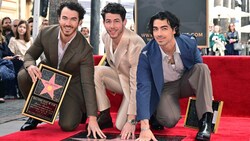 Kevin Jonas, Nick Jonas und Joe Jonas von der US-Band Jonas Brothers posieren für Fotos mit ihrem neu enthüllten Stern auf dem „Hollywood Walk of Fame“ (Bild: APA / Photo by Frederic J. BROWN / AFP)