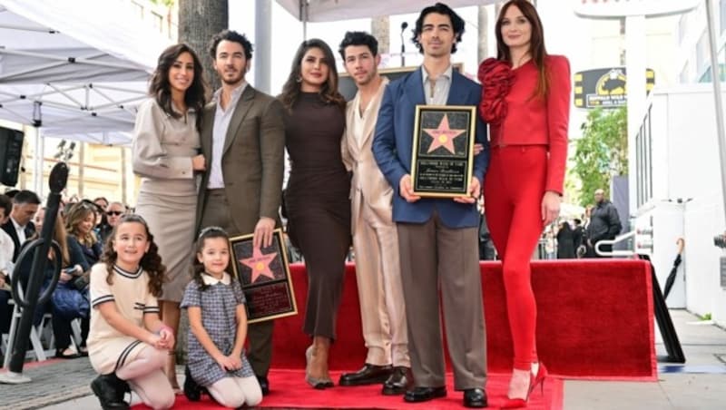 Die Jonas Brothers mit ihren Ehefrauen und Kindern am „Walk of Fame“ (Bild: AP'A/Photo by Frederic J. BROWN / AFP)