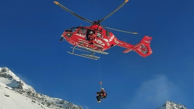 Hundeführer und Vierbeiner werden mit der Winde des Aiut Alpin runtergelassen. (Bild: Bergrettung Prägraten)