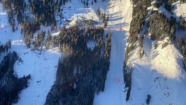 Entlang der roten Linie verläuft der Forstweg. Der Schneepflug wurde 200 Meter von der Lawine mitgerissen (roter Kreis). (Bild: Polizei Tirol)