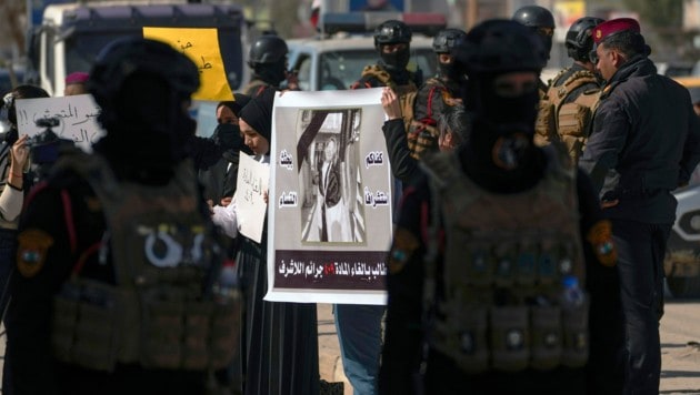 Irakische Frauen demonstrieren in Diwaniya mit einem Plakat der getöteten YouTuberin Tiba Ali für härtere Strafen bei häuslicher Gewalt. (Bild: AP)