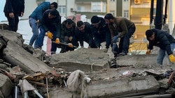 Diese Männer in der türkischen Stadt Adana versuchen, mit bloßen Händen Trümmer zu beseitigen, um Verschüttete zu finden. (Bild: AP)