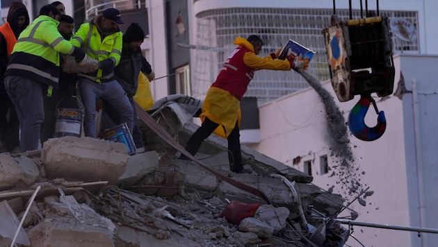 Retter suchen in Adana in der Südtürkei nach Überlebenden in den Trümmern. (Bild: Associated Press)