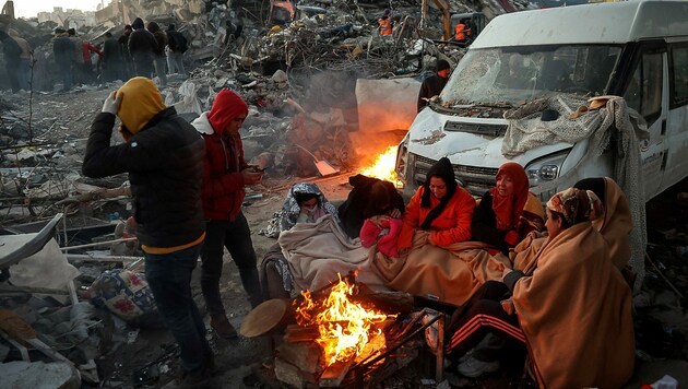 Bei eisiger Kälte müssen Überlebende, die alles verloren haben, im Freien übernachten. (Bild: APA/AFP/Adem ALTAN)