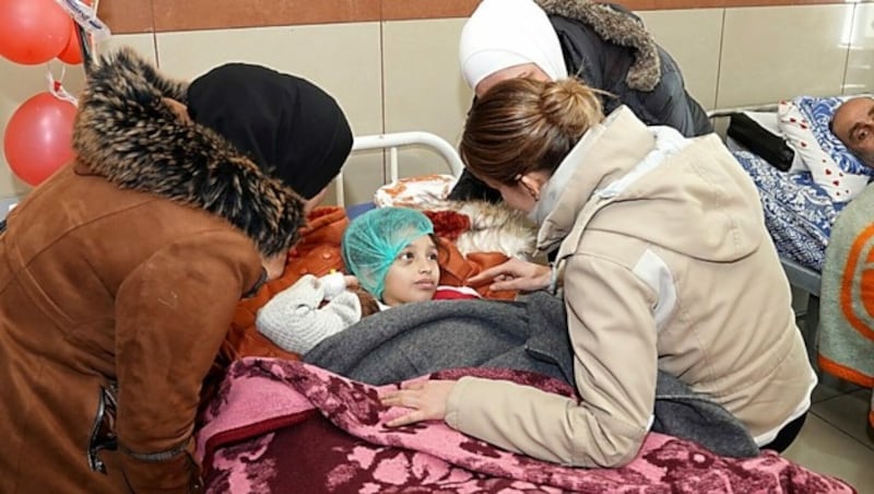 Die syrische Präsidentengattin Asma al-Assad (helle Jacke) am Spitalsbett eines verletzten Mädchens (Bild: APA/AFP/Syrian Presidency Facebook Page)