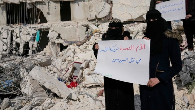 Zorn und Wut greifen in Syrien um sich, die Menschen fühlen sich im Stich gelassen. „Die UNO ist Partner von Bashar al-Assad und tötet Syrer“, ist auf dem Schild dieser Frauen zu lesen. Radikale Islamistengruppen kontrollieren immer noch einige Städte im Norden Syriens. (Bild: AP)