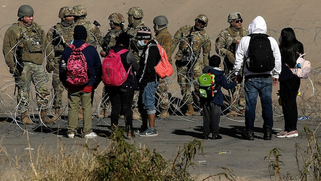 US-Grenzschützer mit einer Gruppe von Migranten an der Grenze zu Mexiko bei El Paso (Texas) (Bild: APA/AFP/Herika Martinez)