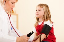 Bei den regelmäßigen Vorsorgeuntersuchungen misst der Kinderarzt den Blutdruck. (Bild: Kzenon - stock.adobe.com)