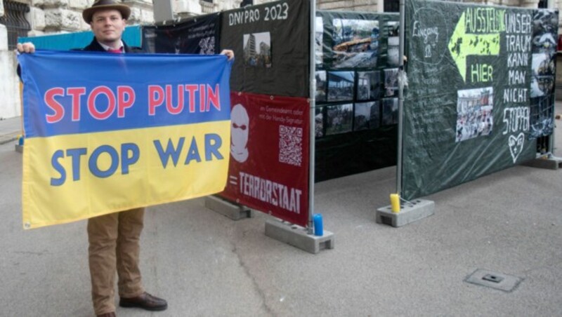 Ein Mann hält eine ukrainische Flagge mit der Aufschrift „Stoppt Putin - Stoppt den Krieg“ vor der Hofburg in Wien. (Bild: AFP or licensors)