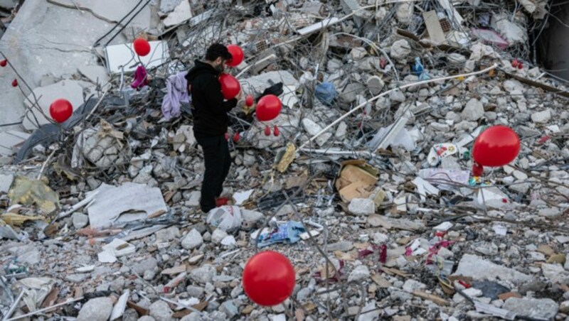 Ein Mann auf den Trümmern eines eingestürzten Gebäudes in Antakya (Bild: AFP)