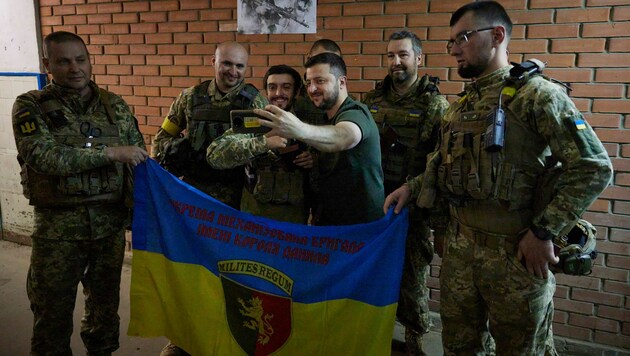 Entschlossen und zuversichtlich: Der ukrainische Präsident Wolodymyr Selenskyj macht ein Selfie mit Soldaten. (Bild: AP)