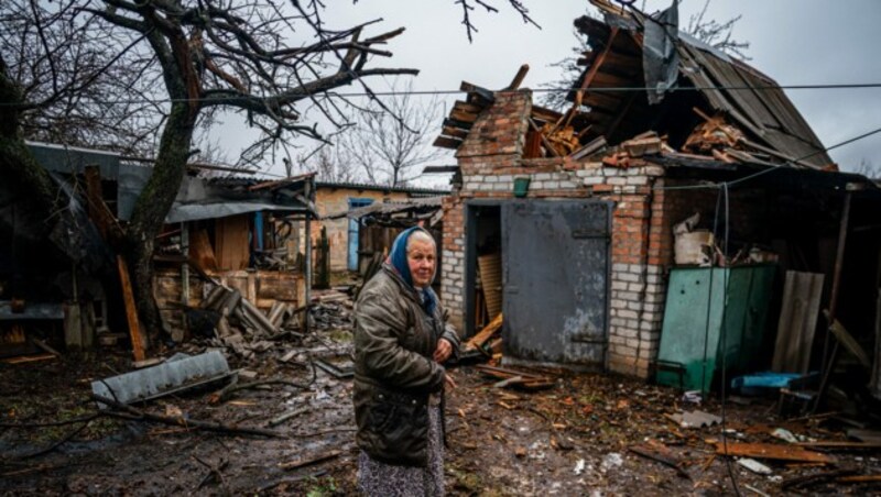 Ein ältere Dame im Hof ihres zerbombten Heims nahe Bachmut (Bild: AFP)