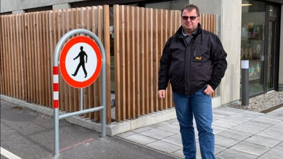 Bezirksrat Werner Thalmayr (SPÖ) leitet die Fußgänger auf die andere Straßenseite um. (Bild: Screenshot/SPÖ-Simmering/facebook.com)