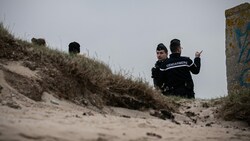 Gendarmen der Hundestaffel „Cynophile“ patrouillieren am Strand der Batterie Blankenese in Neville sur Mer, Nordwestfrankreich. Die bisher angeschwemmten Drogen haben einen geschätzten Verkaufswert von fast 150 Millionen Euro. (Bild: AFP/Lou BENOIST)