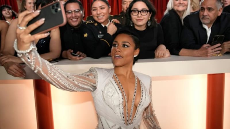 Ariana DeBose takes a selfie with fans on carpet at the Oscars on Sunday, March 12, 2023, at the Dolby Theatre in Los Angeles. (AP Photo/John Locher) (Bild: APA/John Locher/Invision/AP)