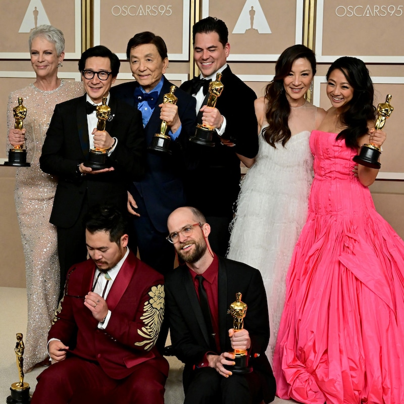 Von links: Jamie Lee Curtis, Ke Huy Quan, James Hong, Jonathan Wang, Michelle Yeoh, Stephanie Hsu, Daniel Kwan (unten links) und Daniel Scheinert (unten rechts) posieren mit ihren Oscar-Trophäen. (Bild: APA / Photo by Frederic J. Brown / AFP)