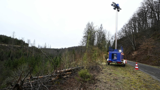 Ein Scheinwerfer des Technischen Hilfswerks (THW) Siegen steht in einem Waldstück, in dem am Sonntag die Leiche eines zwölfjährigen Mädchens gefunden wurde. (Bild: APA/dpa/Roberto Pfeil)