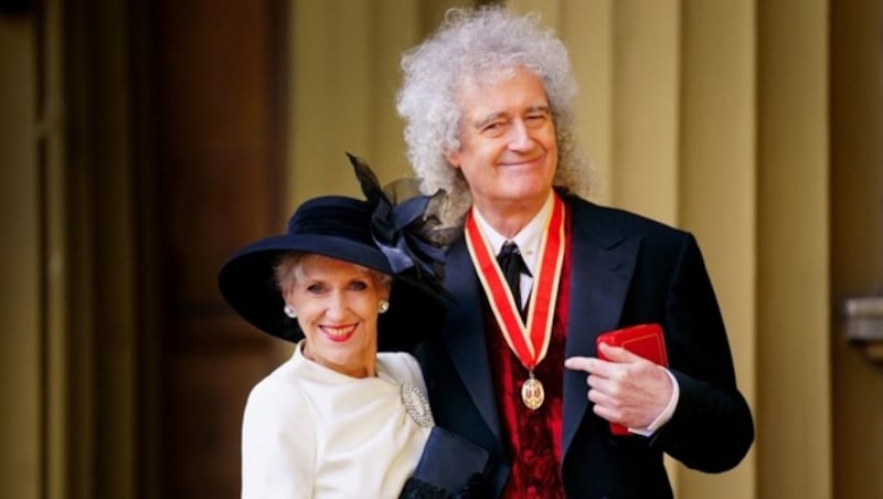 Brian May posiert mit seiner Ehefrau Anita Dobson nach seinem Ritterschlag im Buckingham Palace. (Bild: APA / Photo by Victoria Jones / POOL / AFP)