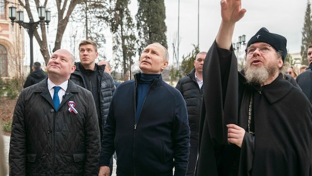 Putin mit dem Gouverneur von Sewastopol, Michail Raswoschajew und einem orthodoxen Priester am Samstag auf der Krim (Bild: Sevastopol Governor‘s Press Service)