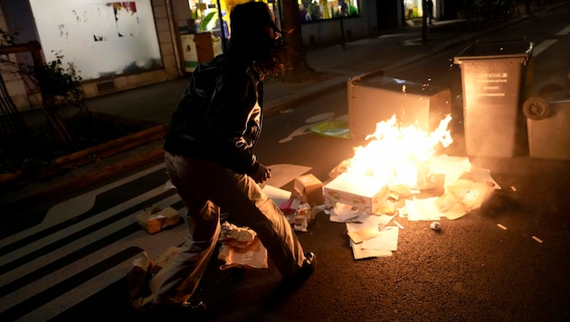 In Frankreich gab es am Samstag wieder Proteste gegen die umstrittene Pensionsreform von Präsident Macron geplant. In den Straßen von Paris wurden Mülltonen in Brand gesetzt. (Bild: The Associated Press)