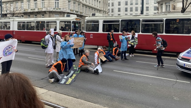 Zuerst spazierten die Aktivisten der Letzten Generation AT die Ringstraße entlang, beim Stubenring klebten sie sich dann fest. (Bild: Letzte Generation AT)